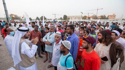 Workers wait to receive food at the event.