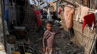 A girl stands next to her destroyed house at Ohn Taw Chay refugee camp in Sittwe, Myanmar, on May 16 after Cyclone Mocha. AFP