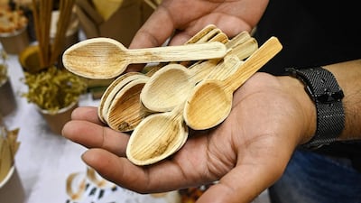 An exhibitor shows spoons made from renewable and environmentally friendly materials in New Delhi. AFP
