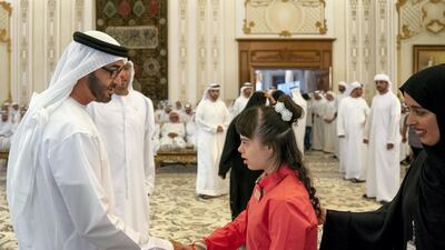 Sheikh Mohamed shakes hands with a member of Zayed Higher Organisation for People of Determination.