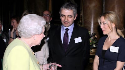 She meets actor Rowan Atkinson and actress Gillian Anderson at Buckingham Palace. Getty