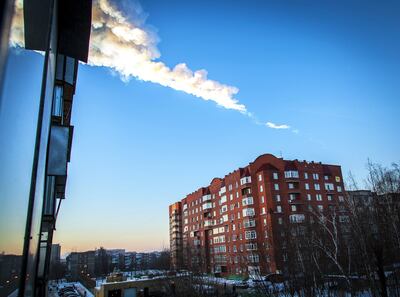 An asteroid trail is seen above a residential apartment block in the Urals city of Chelyabinsk, on February 15, 2013. A heavy meteor shower rained down that day on central Russia, sowing panic as the hurtling space debris smashed windows and injured dozens of stunned locals, officials said. AFP