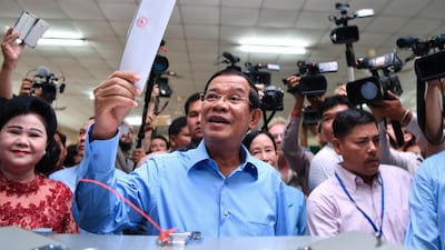 Cambodia's Prime Minister Hun Sen (C) prepares to cast his vote during the general election as his wife Bun Rany (L) looks on in Phnom Penh on July 29, 2018. Cambodia went to the polls early on July 29 in an election set to be easily won by strongman premier Hun Sen after the only credible opposition was dissolved last year, effectively turning the country into a one-party state. / AFP / Manan VATSYAYANA