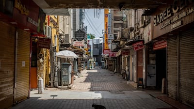 A cat walks in a deserted market area during a weekend lockdown in New Delhi. New curbs to stem the spread of Covid-19 could cost India's economy $1.25bn a week, according to Barclays. AP Photo
