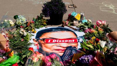 A banner with flowers forms part of a makeshift memorial outside the US Supreme Court as people pay their respects to Ginsburg in Washington. AFP