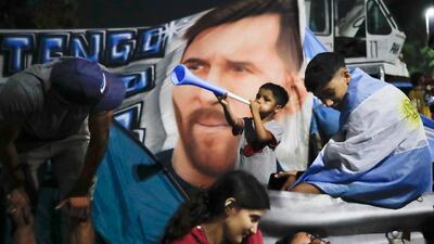 Fans in front of a banner of Lionel Messi. Getty Images