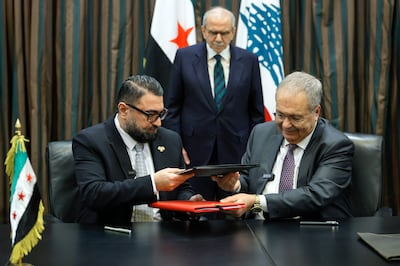 Lebanese Prime Minister Nawaf Salam looks as Syrian Justice Minister Mazhar Al Wais, left, and Lebanese Deputy Prime Minister Tarek Mitri exchange documents at the signing of a judicial agreement that will see Syrian prisoners in Lebanon transferred to Syria. EPA