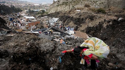 A woman climbs up the mountain after recovering items from her home after it was destroyed in a landslide, in La Paz, Bolivia. Reuters