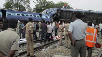 Rescuers stand near the wreckage after the Gorakhpur Express passenger train which slammed into a parked freight train near Basti, Uttar Pradesh state in India on May 26, 2014, killing at least 40 people. AP Photo