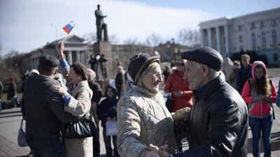 Couples dance outside the Crimean parliament building in Simferopol on March 17, 2014, the day the legislature voted to declare independence from the Ukraine. Dimitar Dilkoff / AFP