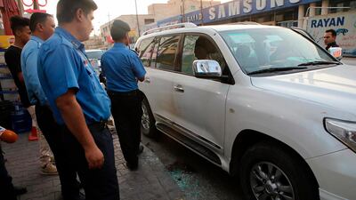 Security forces investigate a vehicle at the site of the assassination of activist Soad al-Ali in Basra, Iraq, Tuesday, Sept. 25, 2018. AP