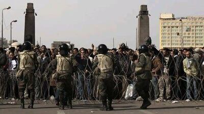 Egyptian soldiers stand behind a makeshift barbed-wire at the entrance of Cairo's Tahrir Square as anti-government demonstrators start massing today. MARCO LONGARI / AFP