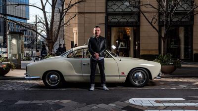 Medical device office worker Tatsuya Aoki posing for a photo with a 1961 Volkswagen Karmann Ghia. AFP