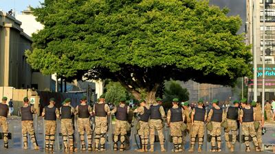 Smoke rises as Lebanese Army soldiers stand guard during a protest against the government performance and worsening economic conditions, in Beirut, Lebanon June. REUTERS
