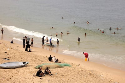 Palestinians gather on the beach to bathe, do their laundry and wash utensils using sea water due to the lack of fresh water and electricity in the southern Gaza Strip on October 29, 2023. AFP