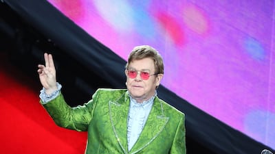 Elton John, in a green brocade suit, performs on stage during Global Citizen Live on September 25, 2021 in Paris, France. Getty Images