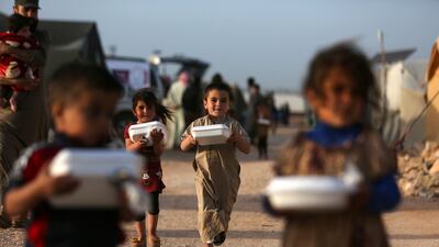 Displaced Syrian children return to their camps with boxes of food on the outskirts of the rebel-held town of Dana, in Idlib province. AFP