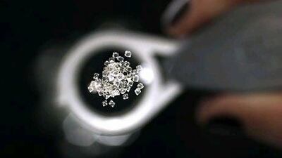 Uncut diamonds from southern Africa and Canada are seen through a jeweller's loupe at De Beers. (REUTERS/Stefan Wermuth).