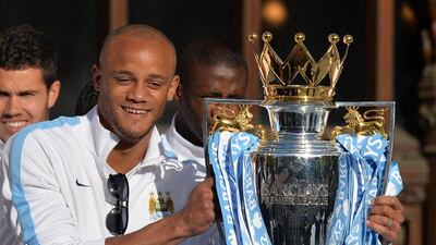 Vincent Kompany poses with the Premier League trophy at Manchester City's title parade in Manchester on Monday. Paul Ellis / AFP / May 12, 2014