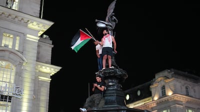 Pro-Palestinian demonstrators climb the statue of Eros in Piccadilly Circus, London. Getty Images