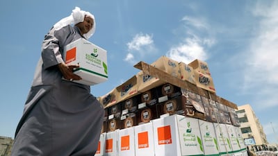 An Egyptian worker distributes food boxes by the Egyptian Food Bank to people who have lost their jobs due to the pandemic, in New Cairo, Egypt. Khaled Elfiqi / EPA