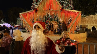 A man dressed as Santa Clause reacts at the Nativity Square before midnight mass at the Nativity Church in Bethlehem on Christmas Eve. AFP