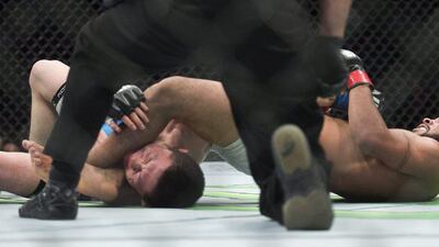 Demetrious Johnson puts Kyoji Horiguchi into an arm bar and gets him to tap out in the flyweight title fight at UFC 186 on Saturday. Graham Hughes / The Canadian Press / AP / April 25, 2015