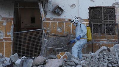 A member of the Syrian civil defence disinfects a destroyed neighbourhood before residents share the iftar meal in Atareb town in the rebel-held western countryside of Aleppo province. AFP