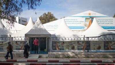 People walk past medical tents where clinical trials for Covid-19 vaccines are conducted in Rabat, Morocco. AP