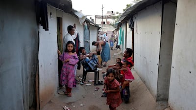 Members of the Rohingya Muslim community sit outside their makeshift houses on the outskirts of Jammu in India. REUTERS