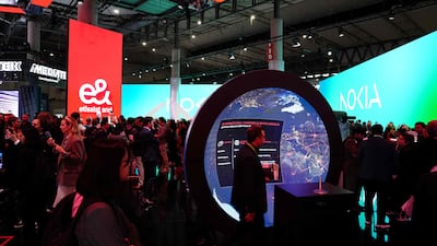 Visitors pass the stand of UAE global technology company e& at the Mobile World Congress in Barcelona. The major industry event is focusing on AI-powered innovations. AFP