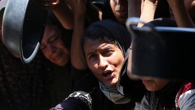 Palestinians wait to receive food from a charity kitchen in Gaza. Reuters