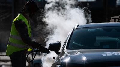 A man cleans and desinfects a taxi car in Stockholm, Sweden, on April 2, 2020, to prevent the spread of the coronavirus, AFP
