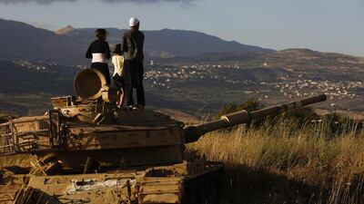 Druze stand on an old Israeli tank in the Israeli-occupied Golan Heights to watch the fighting across border near the Syrian village of Hader. Atef Safadi / EPA / June 20, 2015