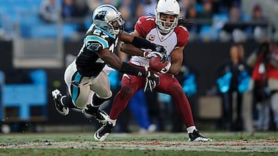 Larry Fitzgerald, right, makes a reception under pressure against the Carolina Panthers.