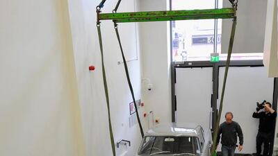 An Aston Martin DB5 used in the film Goldeneye is loaded in to the London Film Museum.