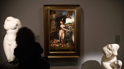 A person looks at a painting by Leonardo da Vinci's " Leda and the Swan " during the opening of the exhibition " Leonardo da Vinci ", at the Louvre museum in Paris.