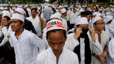 Hardline Muslim groups block a street during a protest against Jakarta's incumbent governor Basuki Tjahaja Purnama (Ahok), an ethnic Chinese Christian running in the upcoming election, in Jakarta, Indonesia, October 14, 2016. The sign reads: "Reject Ahok". Beawiharta/ Reuters
