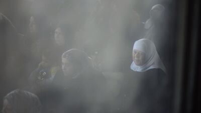 Palestinian women hoping to cross into Egypt are seen through a window as they wait at the Rafah crossing between Egypt and the southern Gaza Strip.