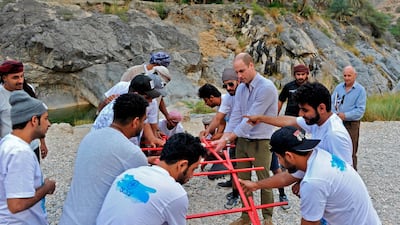 Prince William assembles a structure along with members of the "Outward Bound Oman" non-governmental organisation, in the village of Wadi Arbaeen. AFP