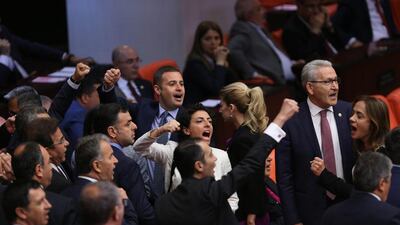 Turkish lawmakers shout slogans ahead of a vote on a bill to remove immunity for lawmakers on Friday. EPA/STR