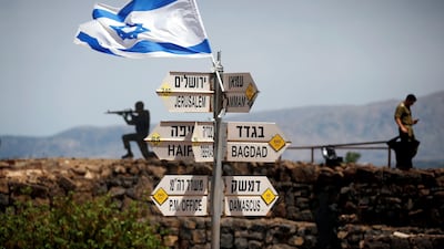 An Israeli soldier stands next to signs pointing out distances to different cities, on Mount Bental, an observation post in the Israeli-occupied Golan Heights . Reuters/Ronen Zvulun