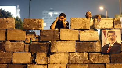 Supporters of former Egyptian president Mohamed Morsi gather at the Raba Al Adaawyia Mosque last summer in Cairo. The men were forcibly dispersed a short time later. Mahmoud Khaled / AFP