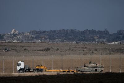 An Israeli tank is loaded on to a transporter on the Israel-Gaza border. AP