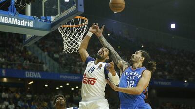 Oklahoma City Thunder centre Steven Adams right, reaches for a loose ball against Real Madrid. Daniel Ochoa de Olza / AP
