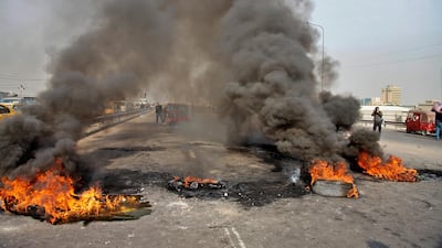 Anti-government protesters set fires to close a highway during ongoing protests in downtown Baghdad. AP