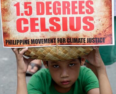 FILE - A boy holds a message during a climate change rally in the Philippines urging the world to restrict global warming. AP