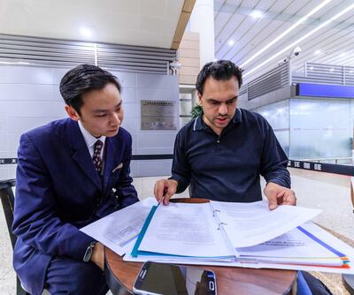 Andrew sits with an airport official in Shanghai to validate his paperwork. Etihad Airways