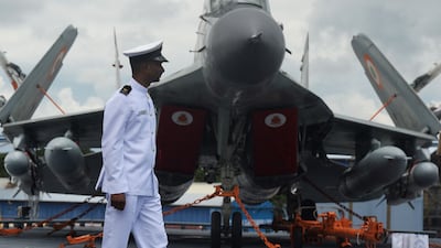 An Indian Navy officer walks past a MiG-29 fighter jet at Cochin Shipyard in Kochi, in September 2022. AFP