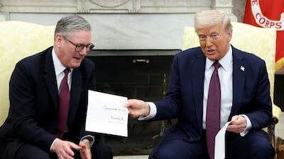 U. S. President Donald Trump holds a letter from Britain's King Charles as he meets with British Prime Minister Keir Starmer in the Oval Office at the White House in Washington, D. C. , U. S. , February 27, 2025. REUTERS / Kevin Lamarque